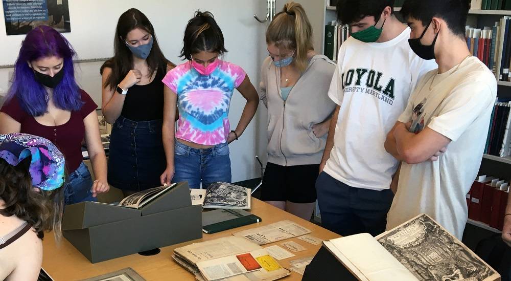 Students examining archival materials on a table