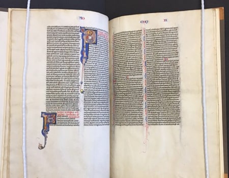 An open manuscript Bible with historiated initials