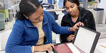 Two students examining a book