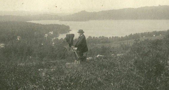 Father John J. Griffin with camera in a field