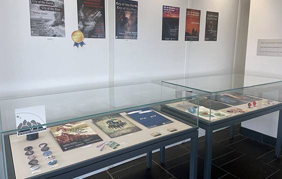 Exhibit case with posters and items created by students, and posters hung on the wall behind the case.