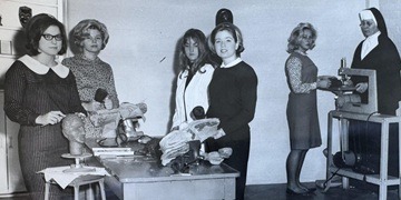 Black and white photograph of five Notre Dame students in an art class with Sister John de Matha