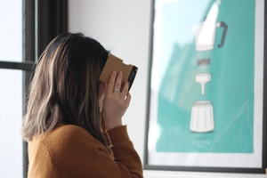 Person with long hair looking at a 360 video through a Google Cardboard