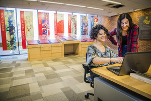 Students using technology on the first floor of the library